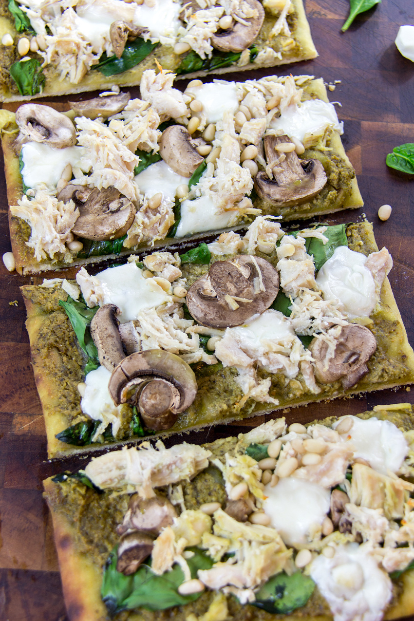 pesto chicken flatbread pizza with mozzarella spinach and mushrooms