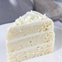 a slice of white cake with white frosting