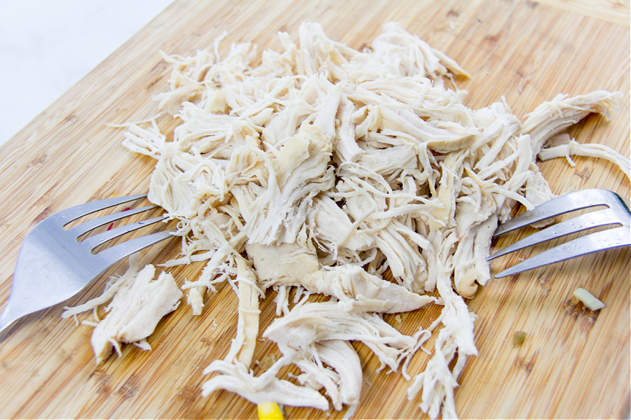 chicken breast shredded on a cutting board