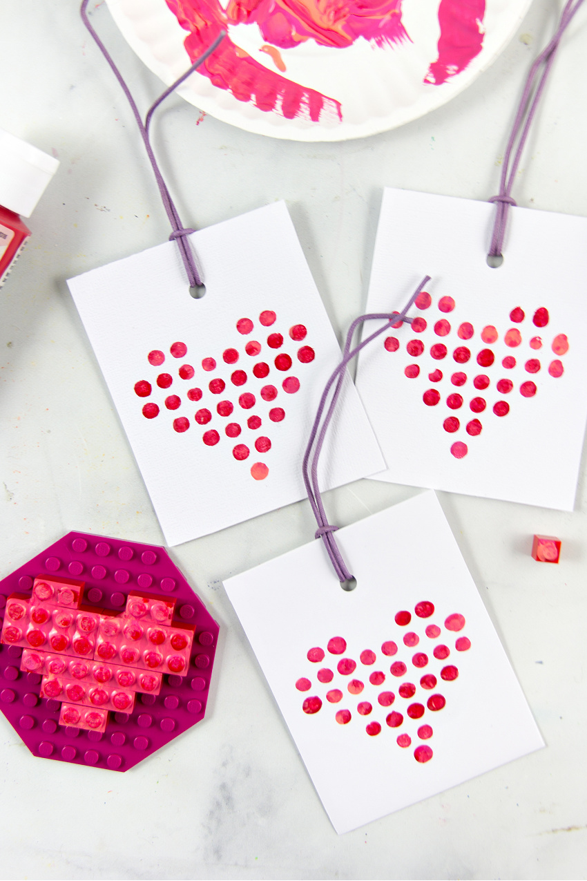 lego shaped like a heart and stamped on card stock with paint to make Valentine's Day cards