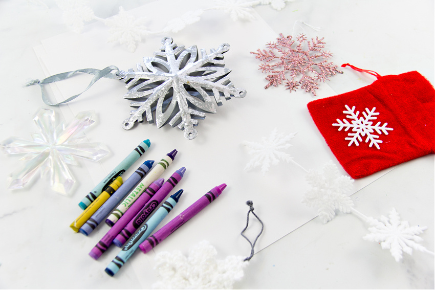 crayons and snowflake ornaments for snowflake rubbings