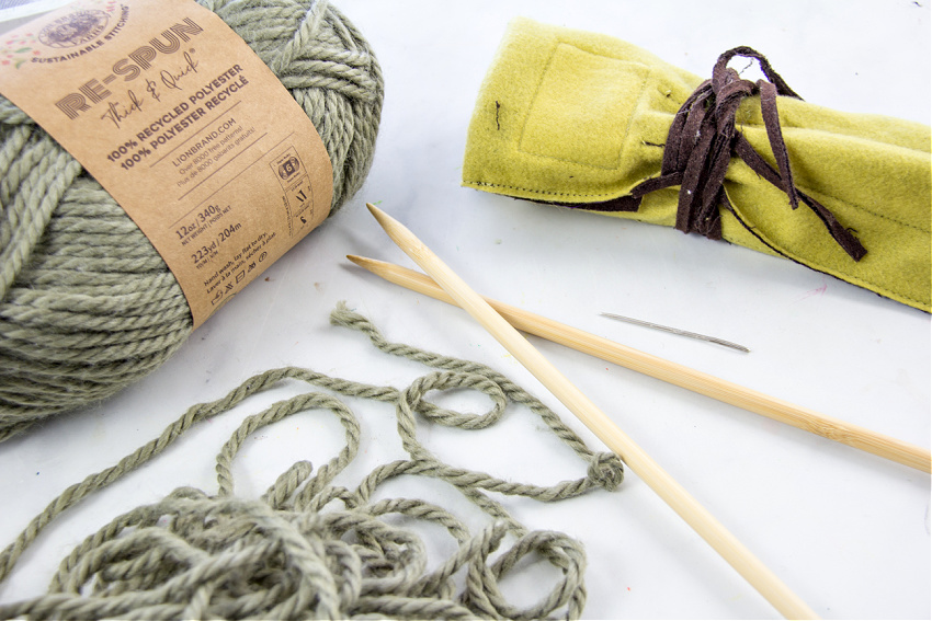 Lion Brand re-spun yarn in olive branch, size 10 knitting needles and a yarn needle for making a knit shawl