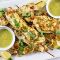 a tray of chicken kabobs with mascarpone dipping sauce