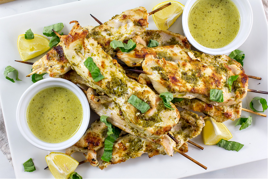 a tray of chicken kabobs with mascarpone dipping sauce