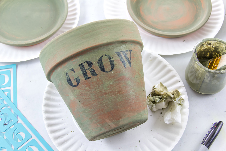 green milk paint being used on a terracotta pot