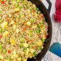 pineapple cashew vegetarian fried rice being cooked in a cast iron skillet