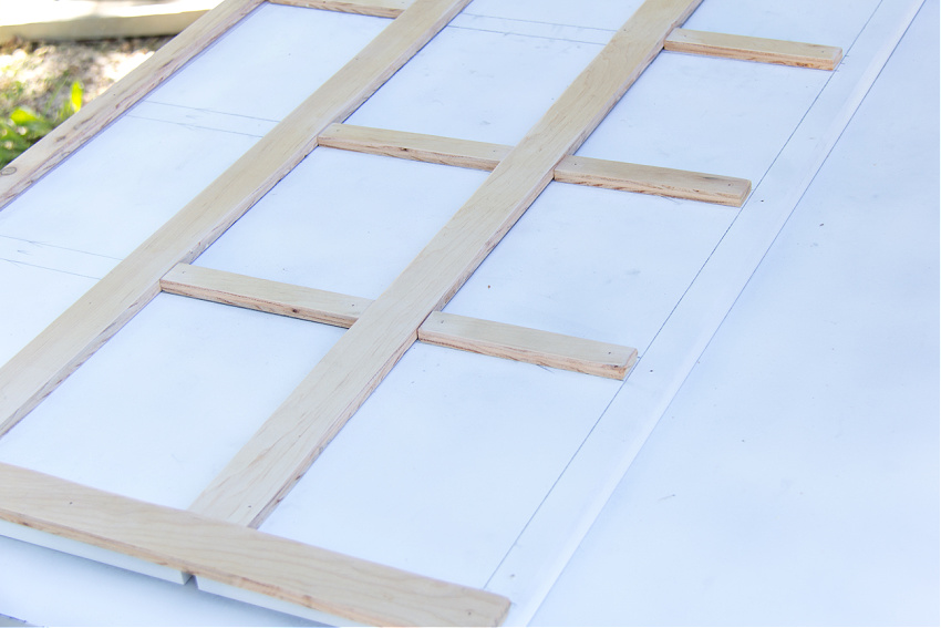 wood panel being laid over a headboard to make a diy wood headboard