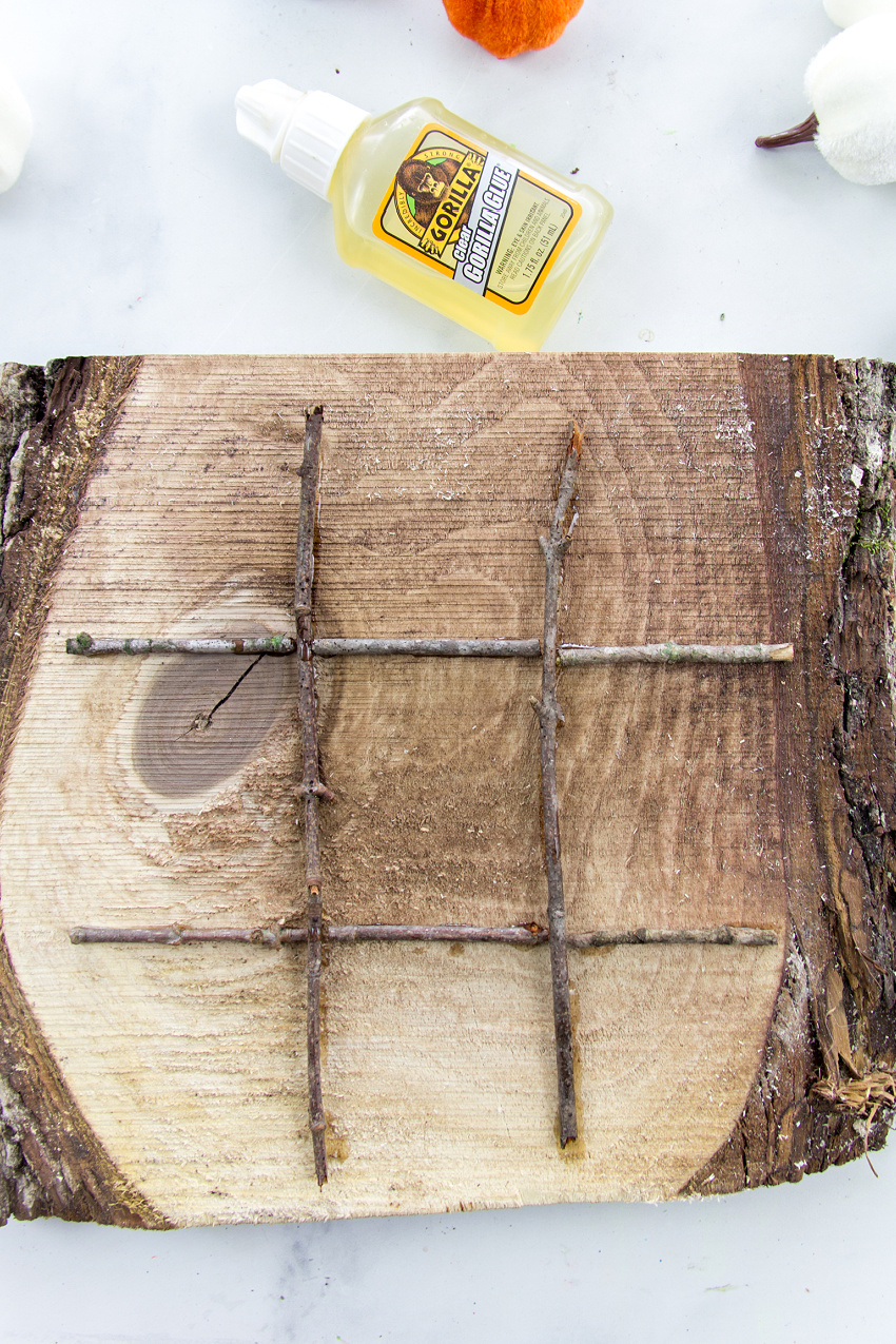 wood tic tac toe board using a wood slice and twigs